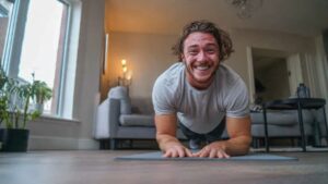 Beginner smiling while doing knee push-ups at home