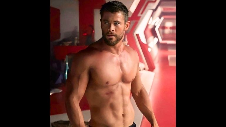 Chris Hemsworth as Thor shirtless, showing ripped abs and broad shoulders